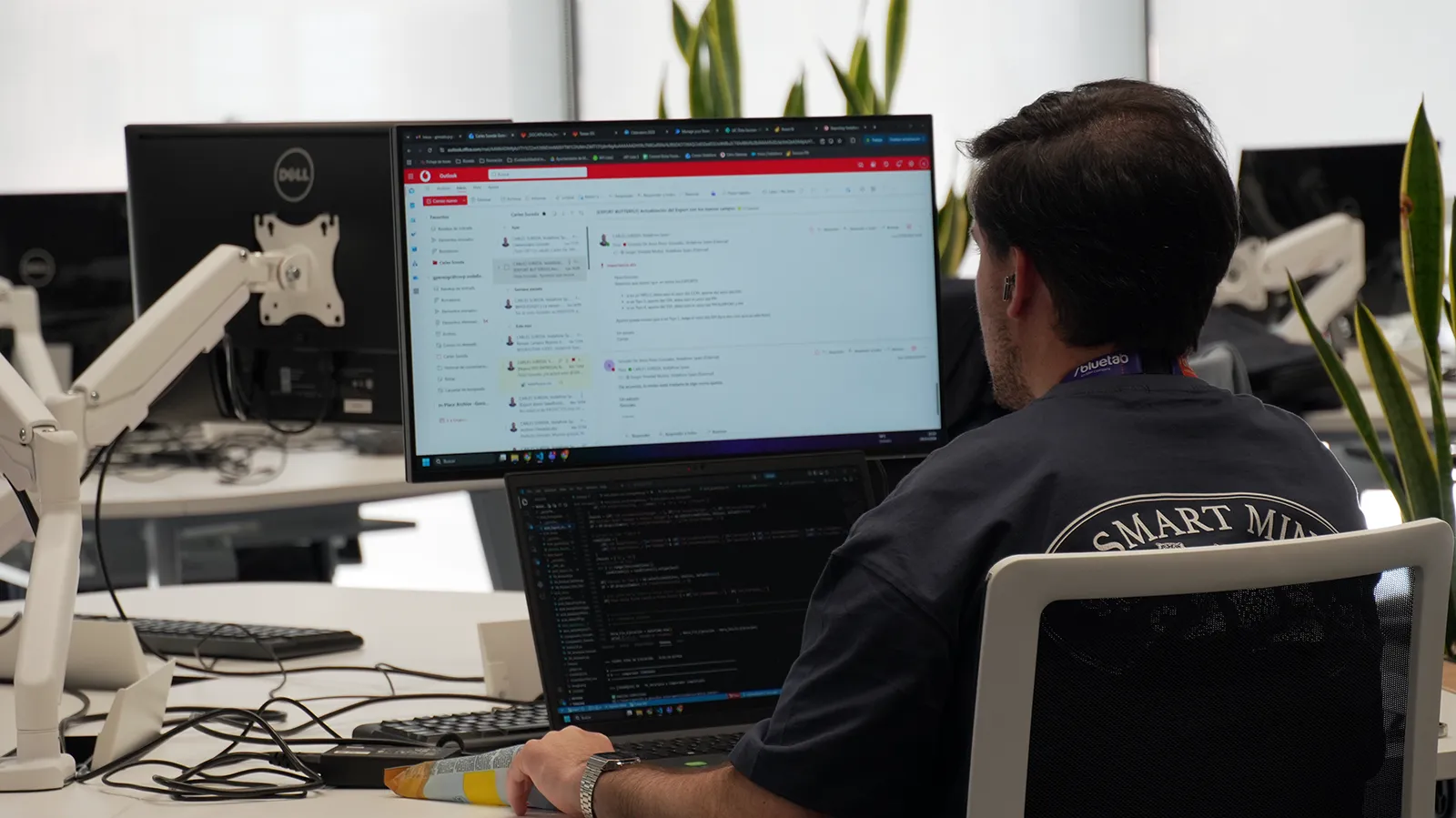 Profesional trabajando en desarrollo y colaboración tecnológica dentro de las oficinas de Bluetab, utilizando herramientas de programación y comunicación digital