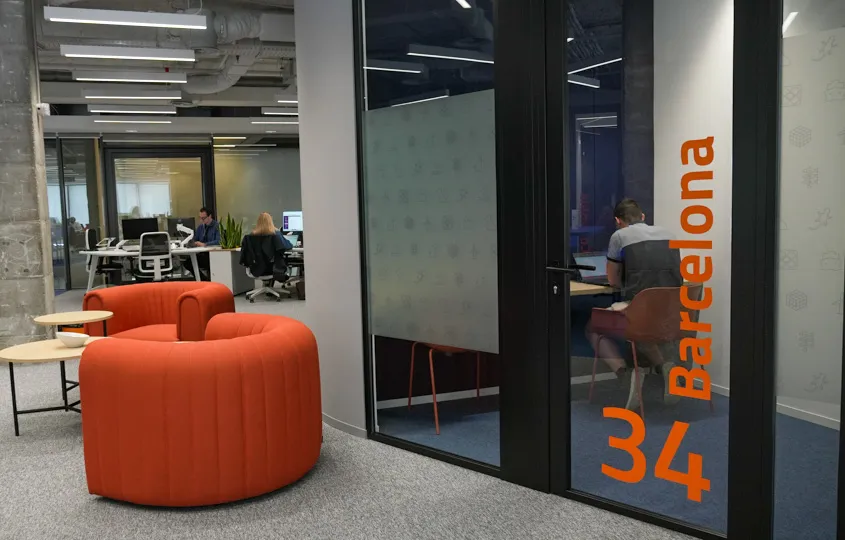 Profesional trabajando en desarrollo y colaboración tecnológica dentro de las oficinas de Bluetab, utilizando herramientas de programación y comunicación digital
