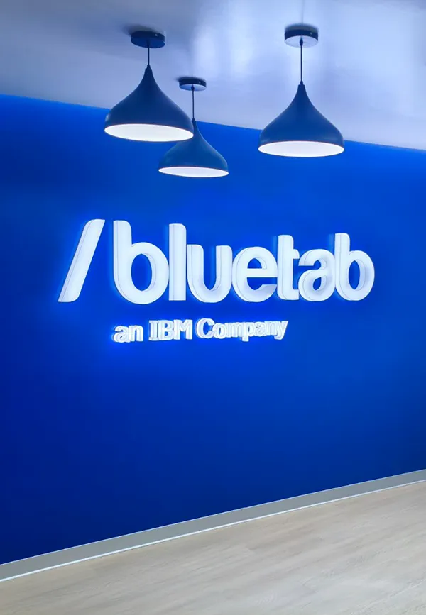 Colaboradores de Bluetab reunidos en una sala de trabajo dentro de una oficina moderna con elementos naturales y ambiente tecnológico